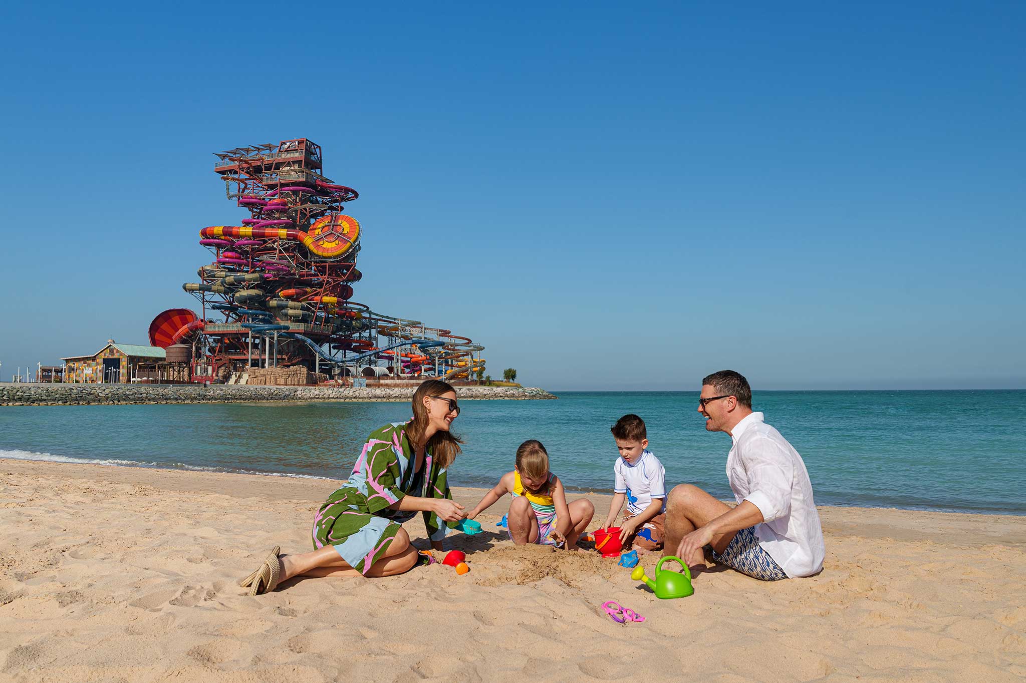 Family on the beach by Rixos Premium Qetaifan Island North