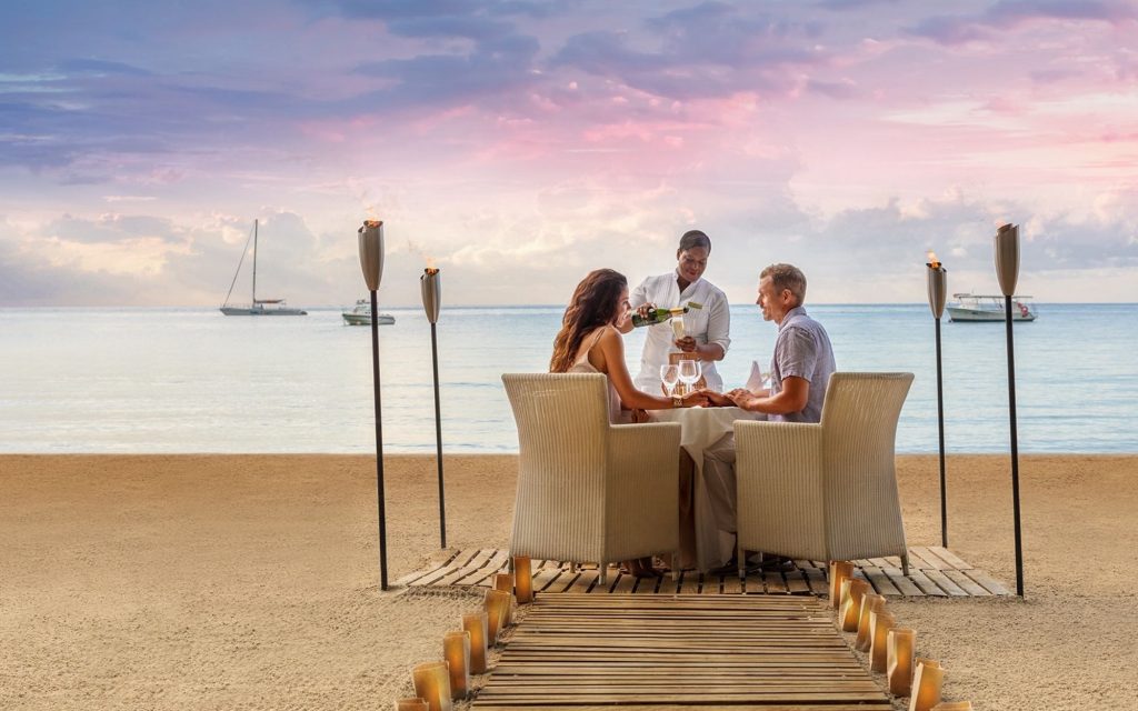 Couple enjoying a private dinner on the beach at Couples Negril