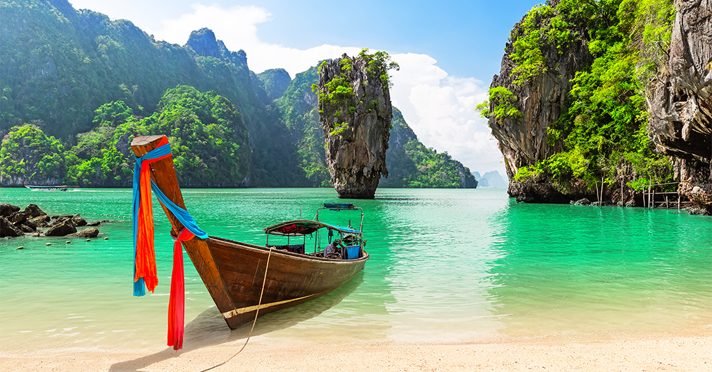A photo of a longboat with the iconic view of James Bond Island in the background