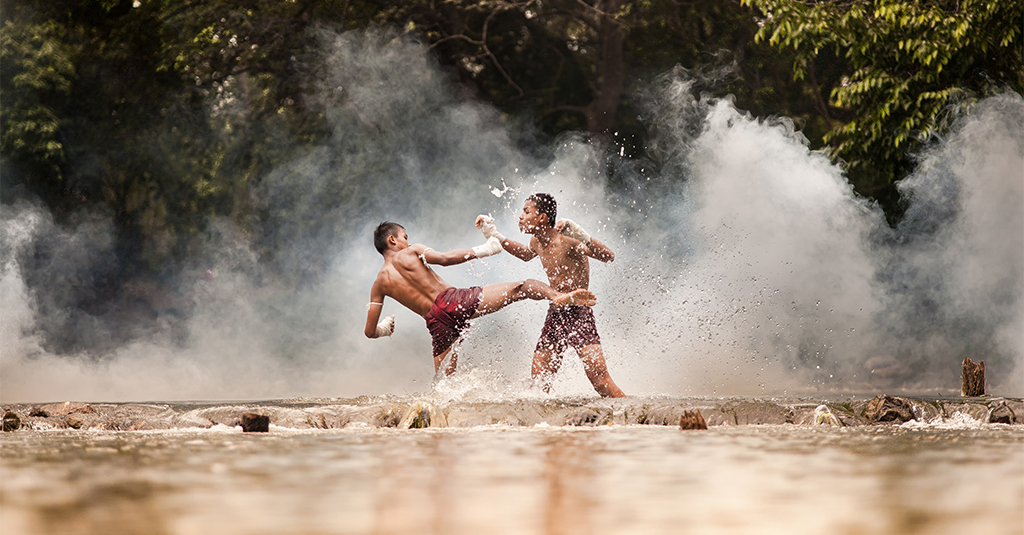 Two Thai Teens practicing Muay Thai Boxing in a shallow river