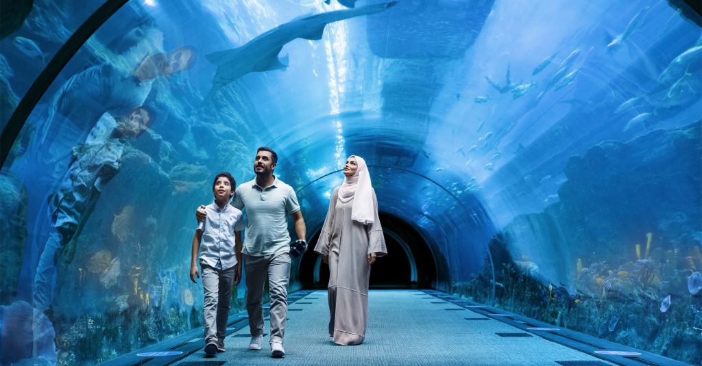 Family walking along Dubai Aquarium & Underwater Zoo tunnel