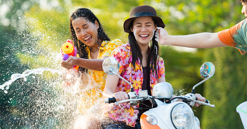 Girls on a scooter with water guns during Songkran Festival 