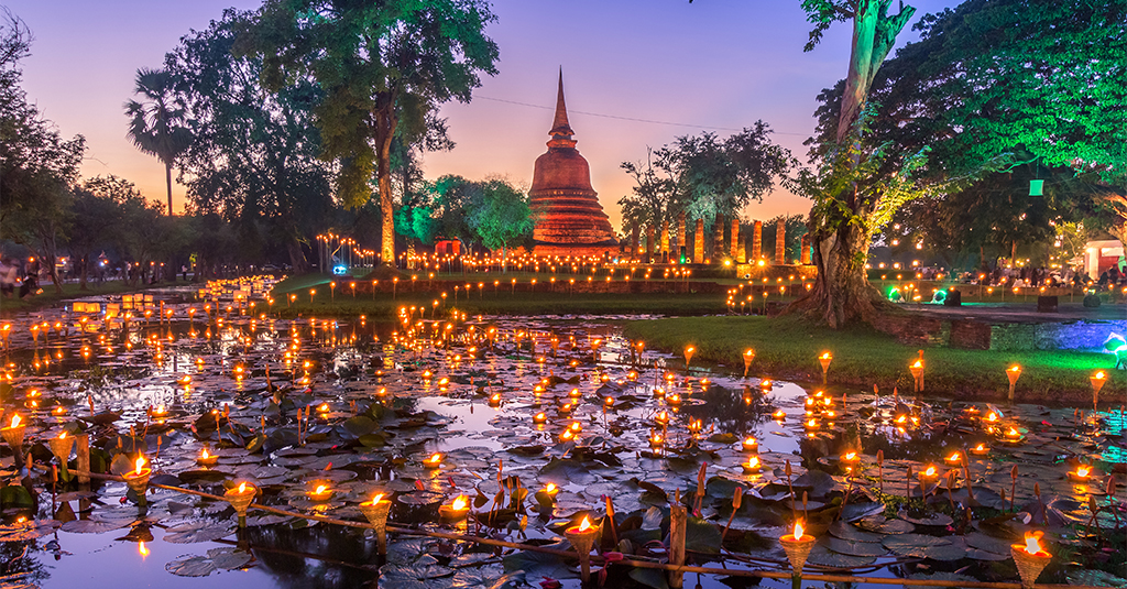 Sukhothai temple at night lit up by candlelight