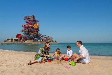 Family on the beach by Rixos Premium Qetaifan Island North