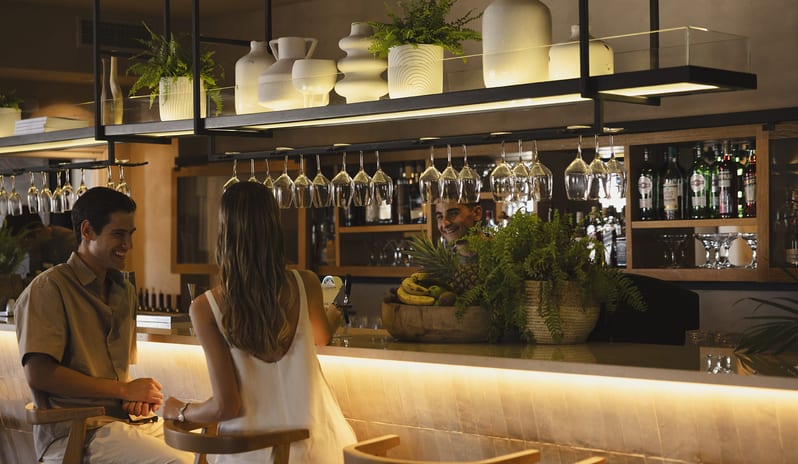 Blu Bar Elegant seating area with wooden bar stools at Domes Aulūs Elounda by Kenwood Travel