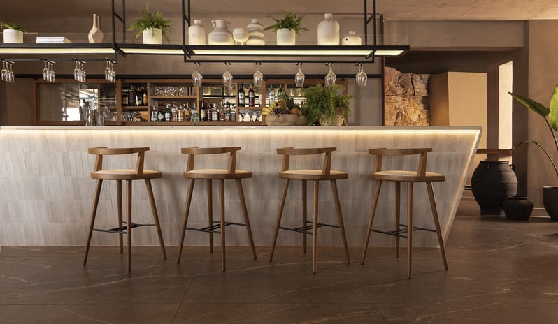 Blu Bar Elegant seating area with wooden bar stools at Domes Aulūs Elounda by Kenwood Travel