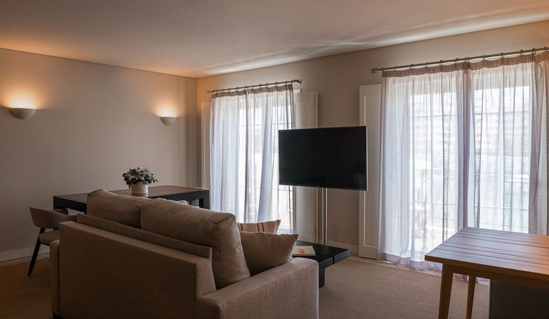 Elite Sapphire One Bedroom Residence Open-plan lounge, dining table for four, flat-screen TV, and contemporary lighting - Kenwood Travel at Domes Lake Algarve by Kenwood Travel