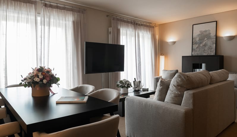 Elite Sapphire One Bedroom Residence Open-plan lounge, dining table for four, flat-screen TV, and contemporary lighting - Kenwood Travel at Domes Lake Algarve by Kenwood Travel