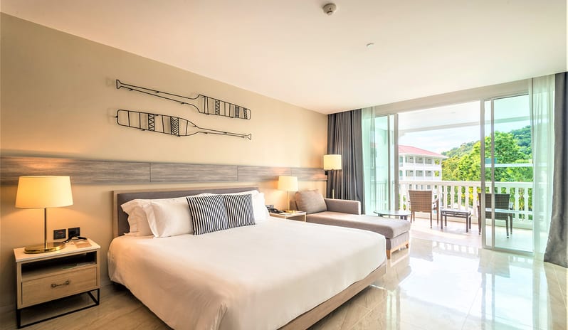 Premium Deluxe Room featuring a king bed, nautical wall art, and a private balcony with palm tree views. at Centara Ao Nang Beach Resort & Spa Krabi by Kenwood Travel