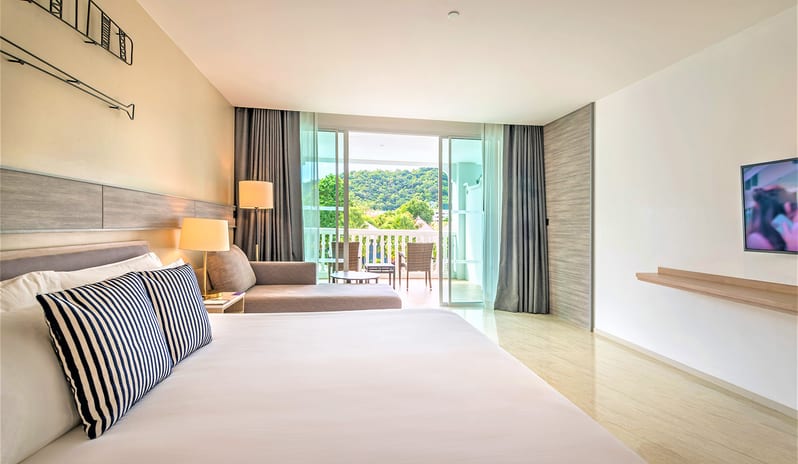 Premium Deluxe Room featuring a king bed, nautical wall art, and a private balcony with palm tree views. at Centara Ao Nang Beach Resort & Spa Krabi by Kenwood Travel