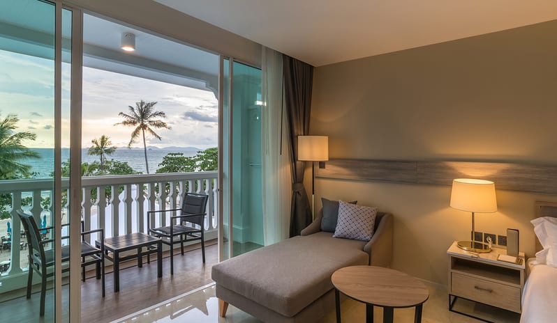 Deluxe Pool Access Room with an ocean view balcony featuring a chaise lounge, sunset over palm trees, and coastal beach scenery at Centara Ao Nang Beach Resort & Spa Krabi by Kenwood Travel