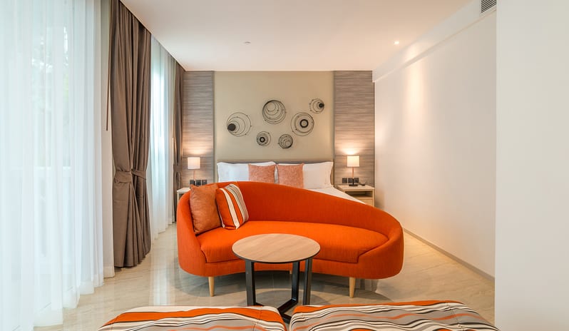Family Residence Bedroom with orange seating area,large windows, and modern decor at Centara Ao Nang Beach Resort & Spa Krabi by Kenwood Travel