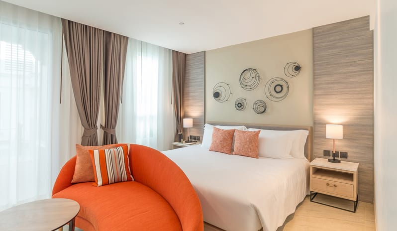 Family Residence Bedroom with orange seating area,large windows, and modern decor at Centara Ao Nang Beach Resort & Spa Krabi by Kenwood Travel