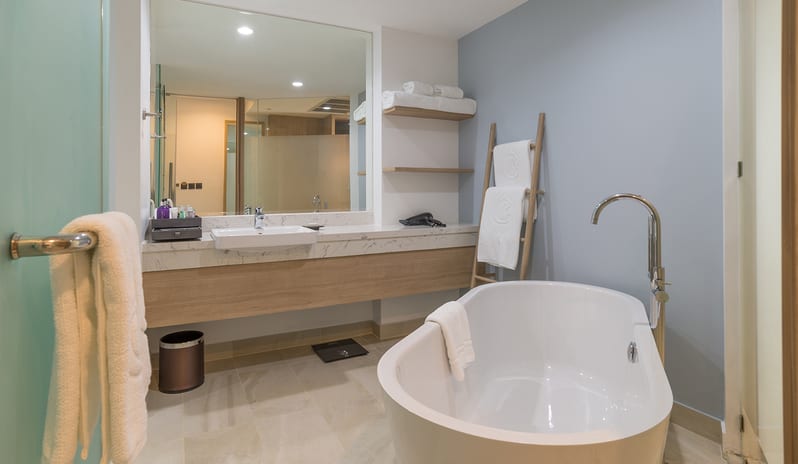 Luxury hotel bathroom featuring a freestanding white soaking tub, marble vanity with large mirror, and light blue accent walls at Centara Ao Nang Beach Resort & Spa Krabi by Kenwood Travel