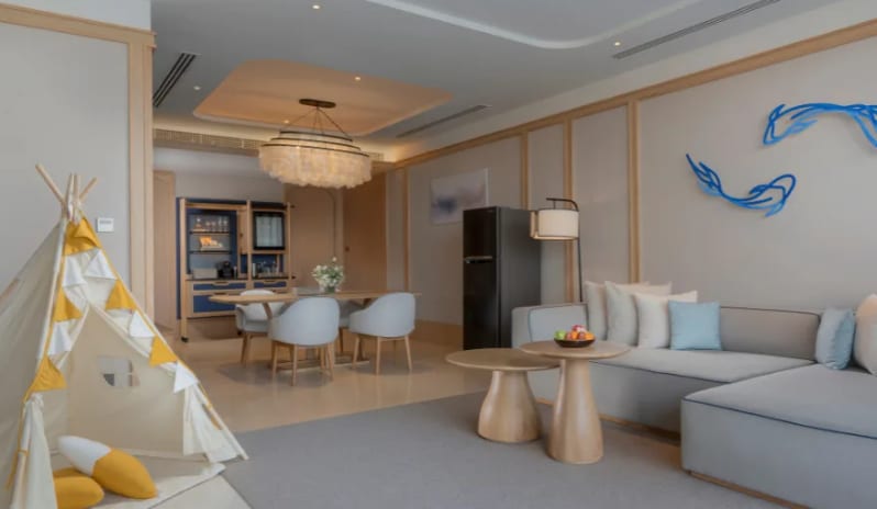 Wellness Lagoon Pool Villa spacious living area, grey sectional sofa, kid's teepee play tent, and elegant dining space at Anantara Koh Yao Yai Resort & Villas by Kenwood Travel