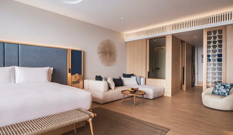 Family Pool View Suite king bed, living area with sectional sofa, and light wood coastal decor at Anantara Koh Yao Yai Resort & Villas by Kenwood Travel