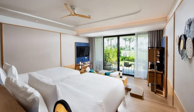 Deluxe Garden Access Suite elevated bed overlooking a private garden terrace through floor-to-ceiling glass doors at Anantara Koh Yao Yai Resort & Villas by Kenwood Travel