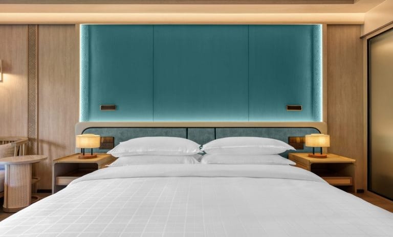Deluxe Premium Contemporary Bedroom Design Featuring Warm Ambient Lighting and Crisp White Linens at Dusit Thani Krabi Beach Resort by Kenwood Travel