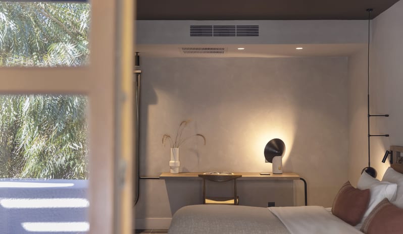 Tropical Bungalow Suite King-Sized Bed with Terracotta Pillows, Minimalist Hanging orb Lights, and a Built-in Wooden Desk Areaat Aulūs Lindos Rhodes, Curio Collection by Hilton by Kenwood Travel