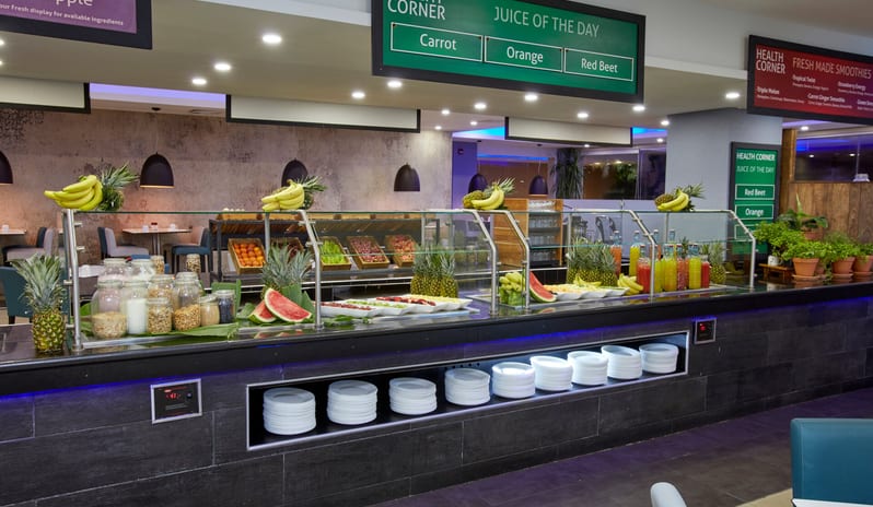 Cunucu Terrace Detailed view of a healthy breakfast bar with assorted whole fruits, sliced watermelon, and jars of grains or nuts in a restaurant setting at Divi Aruba All Inclusive Resort by Kenwood Travel