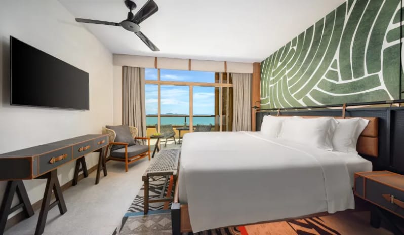 Mirage Suite (King)bed, green patterned accent wall, and a private balcony overlooking the ocean at Centara Grand Mirage Beah Resort by Kenwood Travel