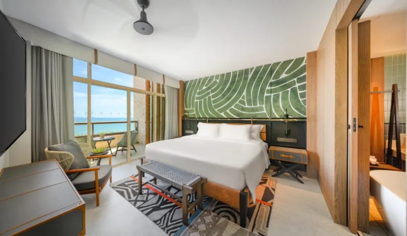 Mirage Suite (King)bed, green patterned accent wall, and a private balcony overlooking the ocean at Centara Grand Mirage Beah Resort by Kenwood Travel