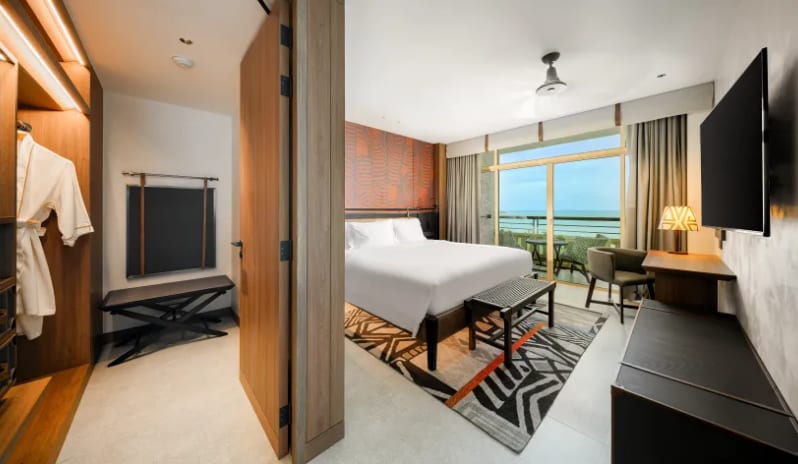 Mirage Family Suite with Bunk Bed (DBL/DBL) bed, tribal-patterned rug, private balcony with ocean view, and a built-in wardrobe with a white bathrobe at Centara Grand Mirage Beah Resort by Kenwood Travel