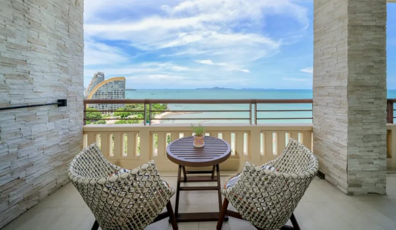 Mirage Family Suite with Bunk Bed (DBL/DBL) Private balcony of the Mirage Family Expedition Suite featuring two woven outdoor chairs, a small round table, and a panoramic view of the ocean and coastline-Kenwood Travel at Centara Grand Mirage Beah Resort by Kenwood Travel