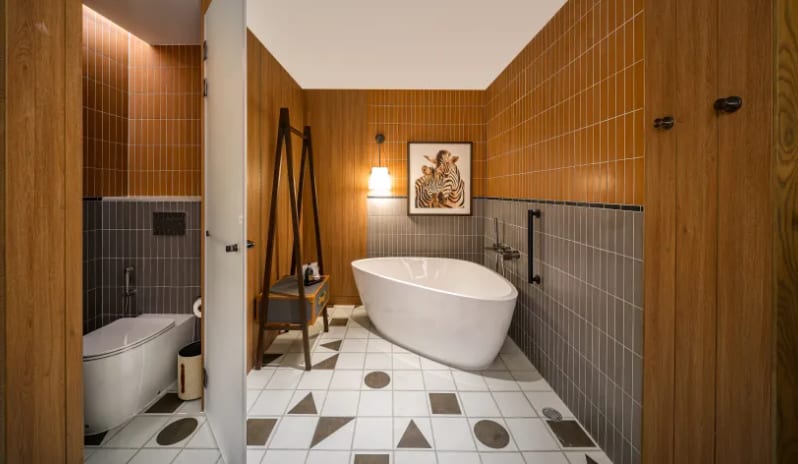 Mirage Family Suite with Bunk Bed (DBL/DBL) bathroom in the Mirage Family Expedition Suite featuring a double vanity with vessel sinks, a standalone soaking tub, geometric floor tiling, and wood-paneled walls at Centara Grand Mirage Beah Resort by Kenwood Travel