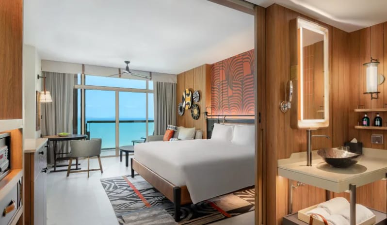 Premium Explorer (King) room with an open-plan bathroom, wooden vanity, and large windows overlooking the ocean at Centara Grand Mirage Beah Resort by Kenwood Travel