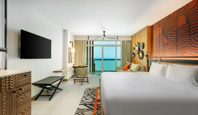 Premium Explorer (King) bed, tribal-patterned decor, and a balcony overlooking the ocean at Centara Grand Mirage Beah Resort by Kenwood Travel