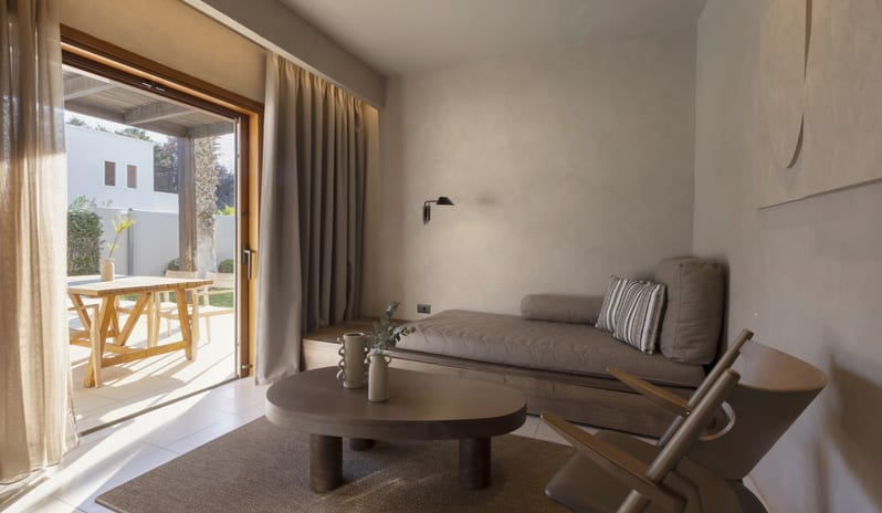 Tropical Bungalow Suite with Private Pool arthy clay-plastered walls, a minimalist daybed, and a low profile coffee table opening to an outdoor patio at Aulūs Lindos Rhodes, Curio Collection by Hilton by Kenwood Travel