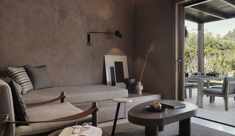 Tropical Bungalow Suite with Private Pool arthy clay-plastered walls, a minimalist daybed, and a low profile coffee table opening to an outdoor patio at Aulūs Lindos Rhodes, Curio Collection by Hilton by Kenwood Travel
