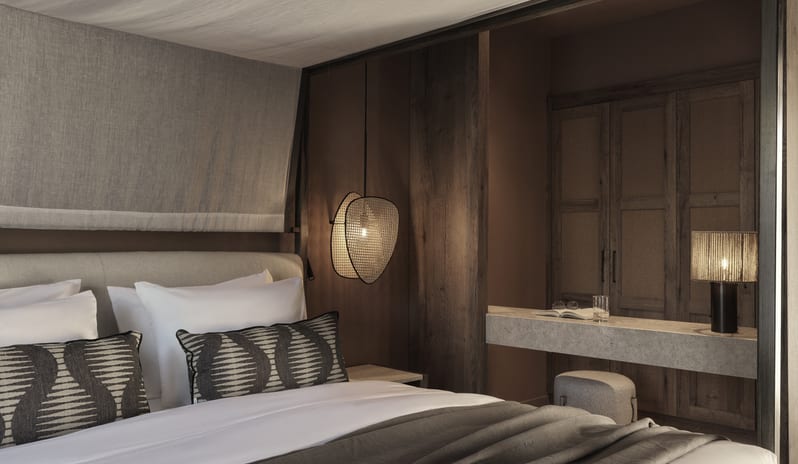 Tropical Bungalow Suite with Private Pool Bedroom Canopy Bed with White draping, dark wood furniture, a private vanity area, and neutral earth-toned decor at Aulūs Lindos Rhodes, Curio Collection by Hilton by Kenwood Travel