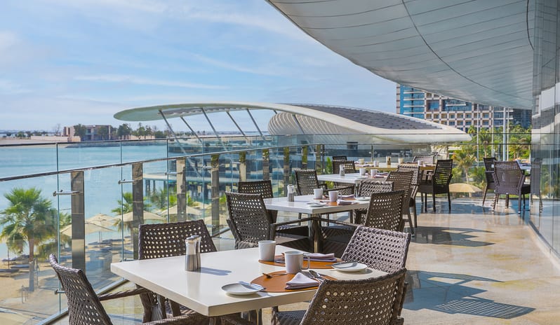 Rosewater Outdoor terrace restaurant seating with sea view at Conrad Abu Dhabi Etihad Towers by Kenwood Travel