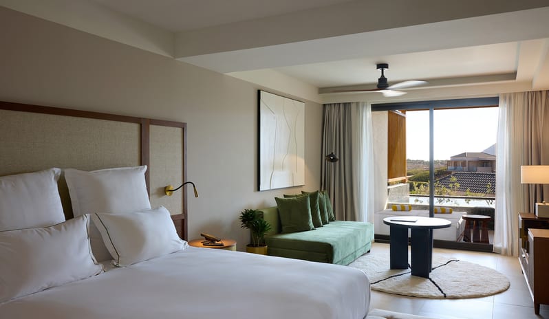Horizon Open Plan Suite with Plunge Pool Bedroom sage green velvet sofa, and floor-to-ceiling windows leading to a private balcony with a plunge pool at Aulūs Chania, Curio Collection by Hilton by Kenwood Travel