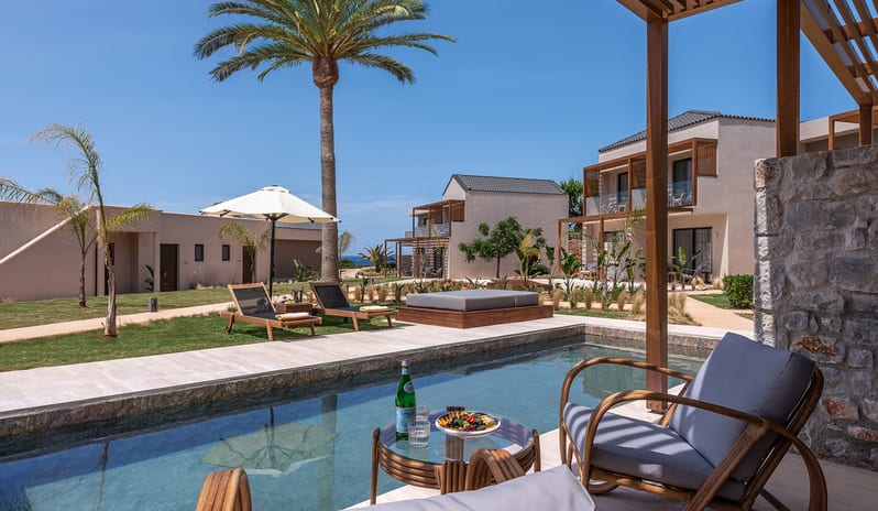 Tropical Open Plan Suite (with shared pool) Private shared pool, modern lounge chairs with a sun umbrella, and a palm tree against a clear blue sky at Aulūs Chania, Curio Collection by Hilton by Kenwood Travel