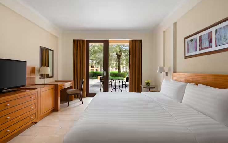 King-size bed and terrace in a Superior Room at Al Waha resort at DoubleTree by Hilton Muscat Al Waha by Kenwood Travel