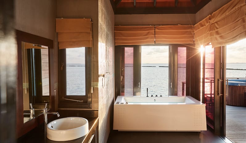 Sunset Horizon Water Villa with Pool Bathroom in an overwater villa featuring a large white soaking tub, a vessel sink at Sun Siyam Iru Fushi-Sunset Horizon Water Villa with Pool  by Kenwood Travel