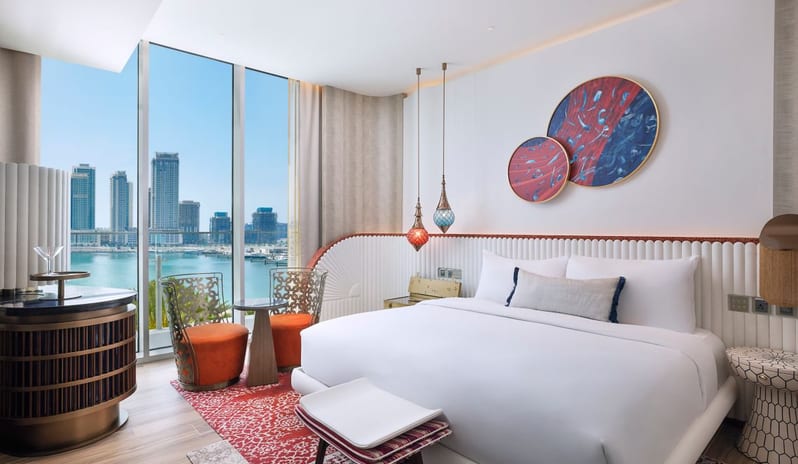 Bedroom vibrant circular wall art, hanging glass lanterns, and a private balcony overlooking the Dubai coastline at W Dubai - Mina Seyahi by Kenwood Travel
