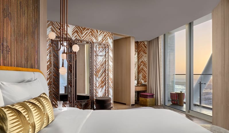 Family Suite Bedroom a unique diamond-patterned accent wall, curved white headboard with gold trim, and chic geometric lighting at W Dubai - Mina Seyahi by Kenwood Travel