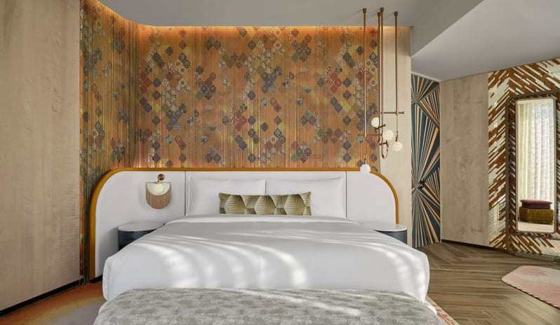 Family Suite Bedroom a unique diamond-patterned accent wall, curved white headboard with gold trim, and chic geometric lighting at W Dubai - Mina Seyahi by Kenwood Travel