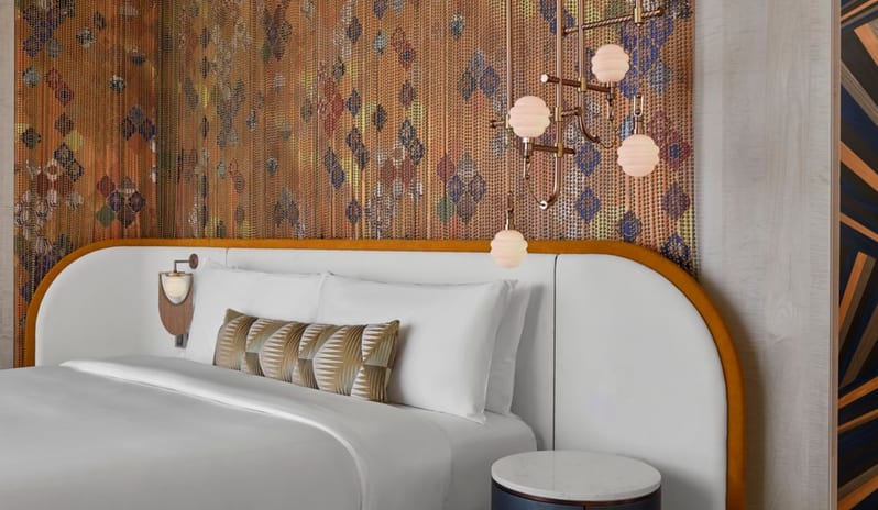 Family Suite Bedroom a unique diamond-patterned accent wall, curved white headboard with gold trim, and chic geometric lighting at W Dubai - Mina Seyahi by Kenwood Travel