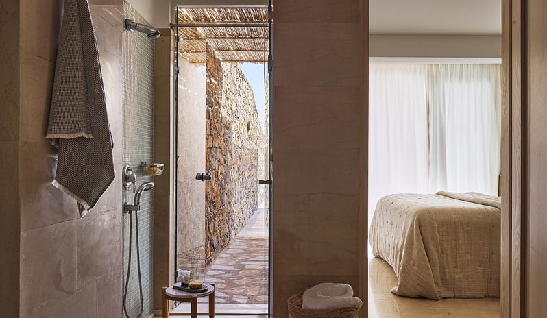 Three Bedroom Thalassa Villa Private Pool Seafront walk-in mosaic tile shower, premium stone finishes, and a doorway leading to a private outdoor stone path at St.Nicolas Bay Resort by Kenwood Travel