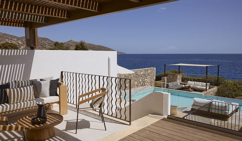 Three Bedroom Thalassa Villa Private Pool Seafront sun loungers with umbrellas, a shaded outdoor lounge area, and panoramic seafront views of the Mediterranean coastline at St.Nicolas Bay Resort by Kenwood Travel
