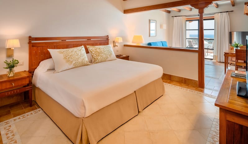 Junior Suite Sea View king-size bed, traditional wooden beams, and a private terrace with a sea view at Princesa Yaiza Suite Hotel Resort by Kenwood Travel