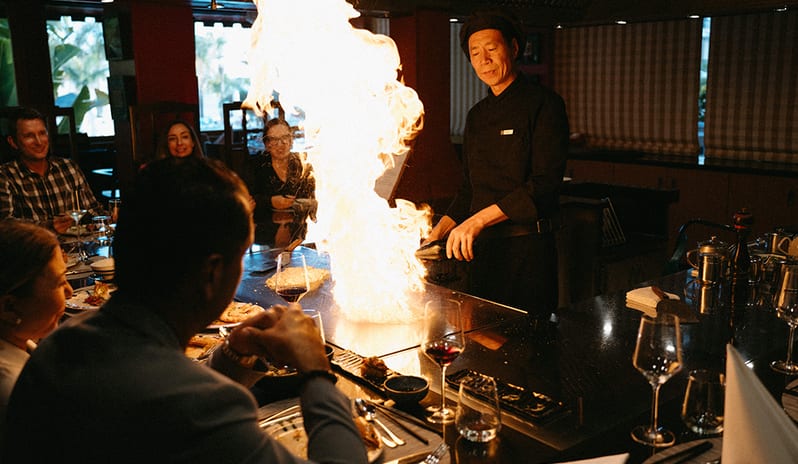 Professional chef performing a live fire show at a teppanyaki grill for guests at Princesa Yaiza Suite Hotel Resort in Europe Holidays by Kenwood Travel