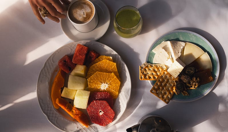 Top-down view of a fresh breakfast at Hacienda including citrus fruits, local cheeses, crackers, and coffee at Princesa Yaiza Suite Hotel Resort in Europe Holidays by Kenwood Travel