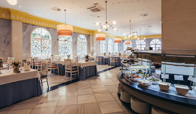 Outdoor terrace seating at Yaiza Buffet with white chairs and palm tree views at Princesa Yaiza Suite Hotel Resort in Europe Holidays by Kenwood Travel