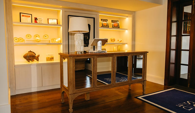 Elegant reception desk at Isla de Lobos restaurant featuring a display of culinary awards and trophies at Princesa Yaiza Suite Hotel Resort in Europe Holidays by Kenwood Travel